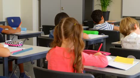 escolares multiétnicos estudiando en un escritorio en un aula de la escuela 4k