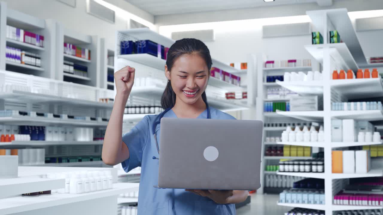 스테토스코프를 들고 노트북을 보고 약국에서 성공을 축하하는 아시아 여성 의사