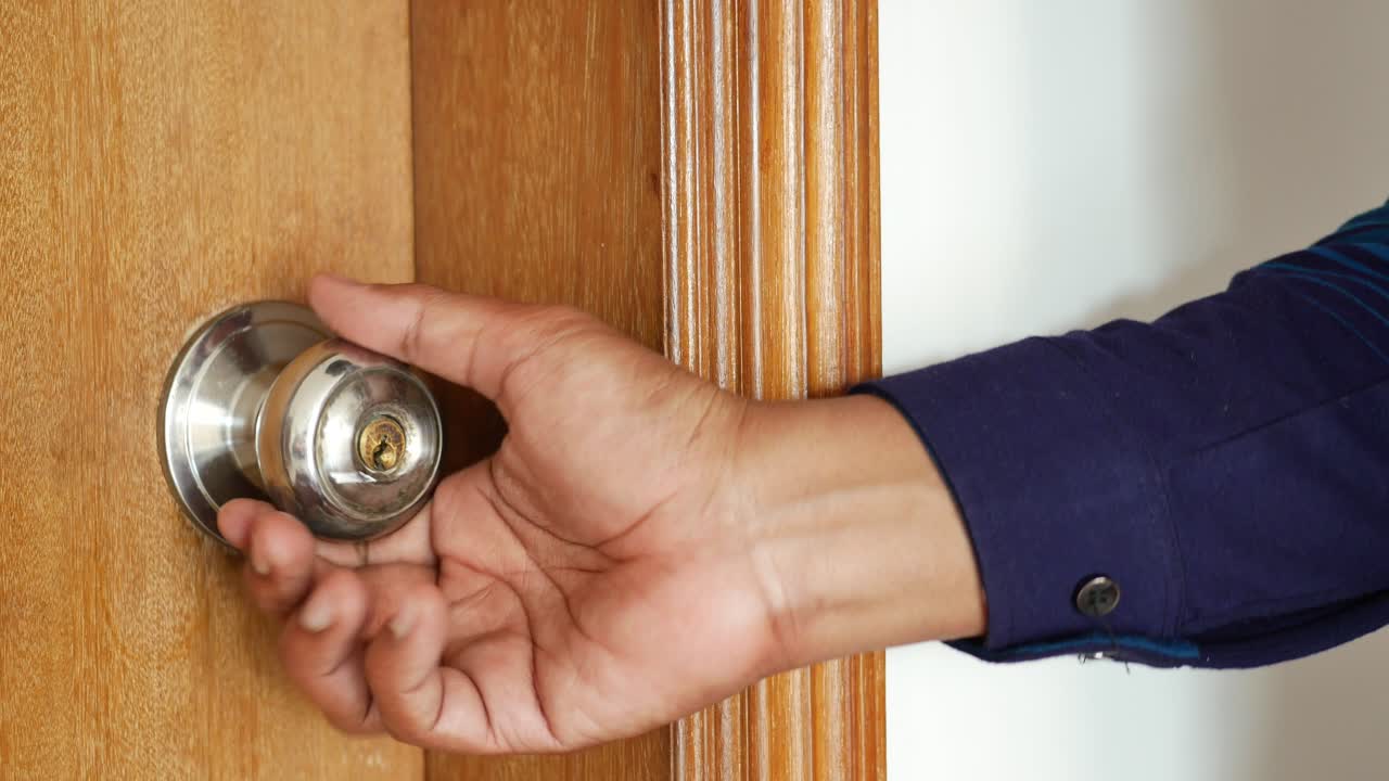 La mano dell'uomo che apre la porta da vicino