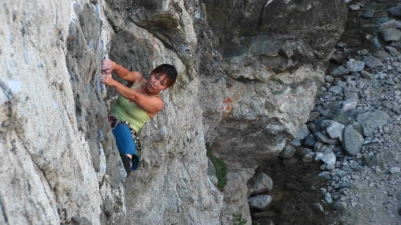 colpo d'uccello di uno scalatore che lotta per tirarsi su una parete rocciosa