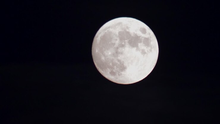 Lua cheia no céu noturno escuro.