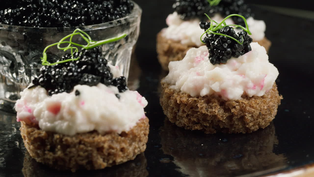 Gourmet canapéer med sort kaviar, creme og mikrogrønt