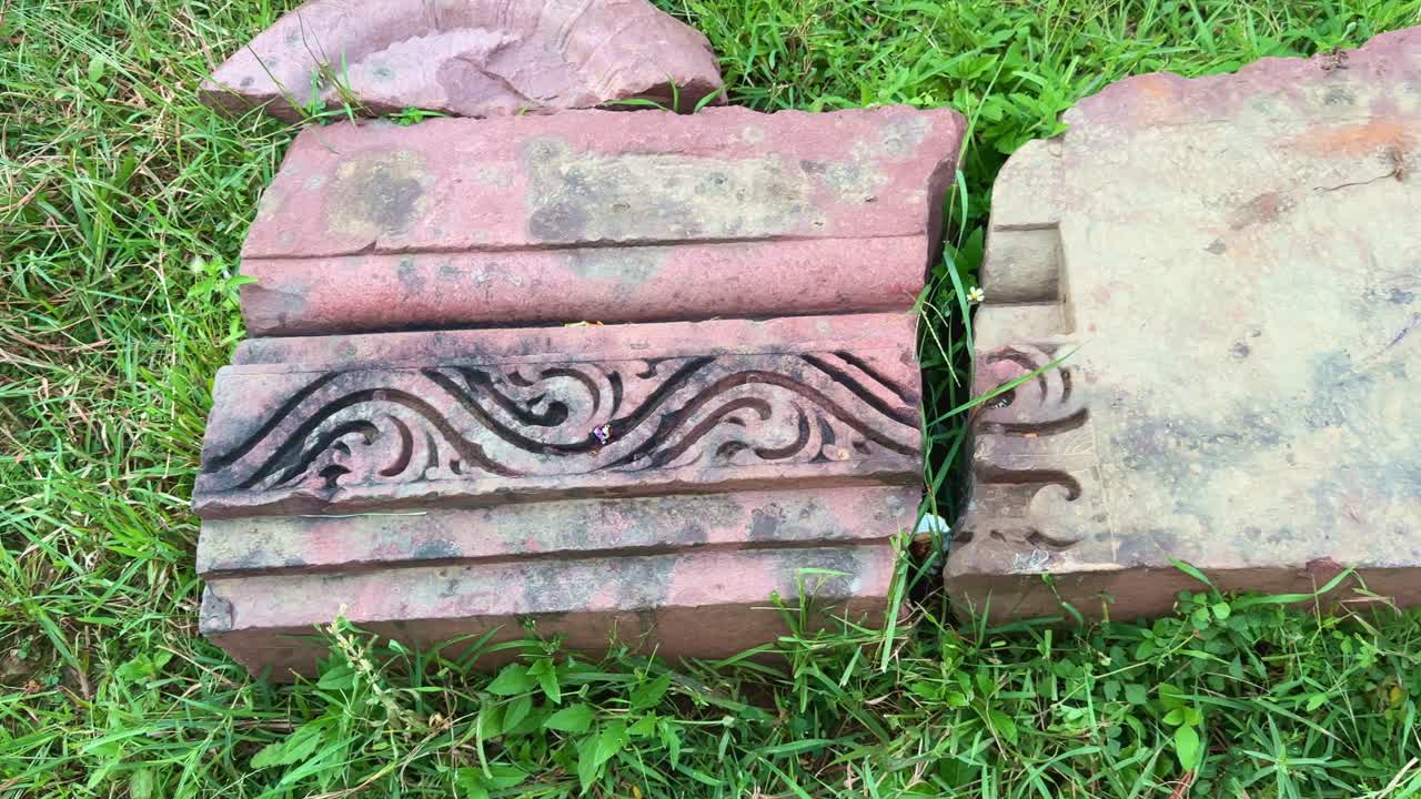 A close-up shot of intricately carved red sandstone fragments from the Bharhut Stupa, showcasing ancient Buddhist artistry and the fine craftsmanship of early Indian stone sculptors
