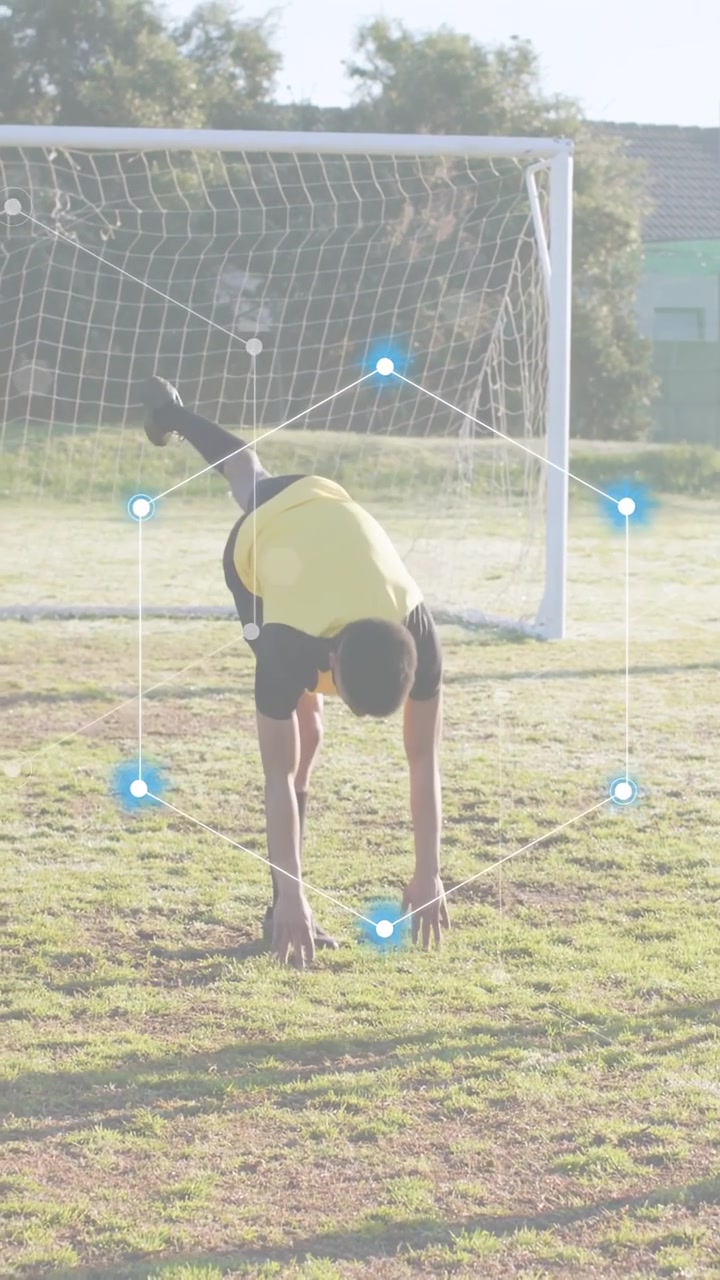 Vertical video: Male player shifting, doing cartwheel in soccer warmup by goal, AR nodes tracking