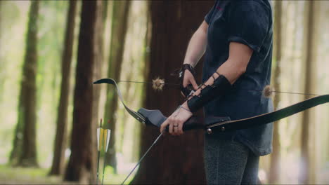 Archery-girl-loads-her-bow-in-a-forest-tilt-medium-shot