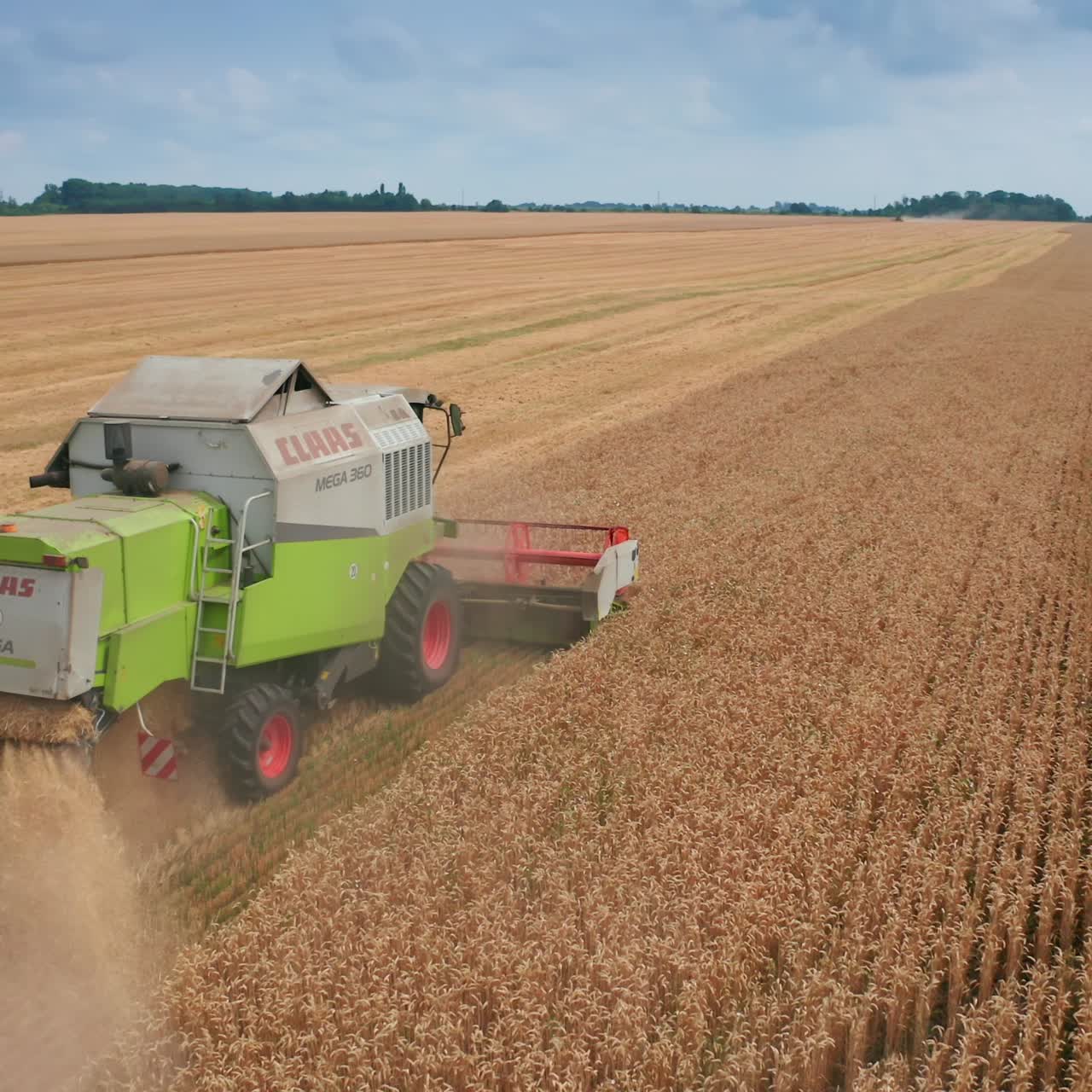 Agricultural huge harvester working on the field. Aerial view combine harvesting wheat field
