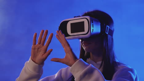 Portrait-Of-Young-Woman-Using-A-Vr-Headset-On-A-Colorful-Neon-Light-Background