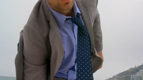 Low-angle-view-of-Caucasian-Businessman-holding-his-briefcase-the-beach-4k