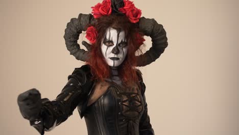 catrina cosplay girl calling with a finger and domina outfit and light background, medium close up