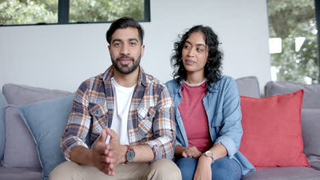 Young-Asian-couple-sits-comfortably-on-a-sofa-at-home-on-a-video-call