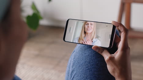 Mujer-Joven-Teniendo-Video-Chat-Usando-Un-Teléfono-Inteligente-En-Casa-Charlando-Con-Un-Amigo-Disfrutando-De-Una-Conversación-Compartiendo-Su-Estilo-De-Vida-En-Un-Teléfono-Móvil