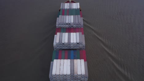 aerial fly over heavily laden container ship navigating on the calm sea