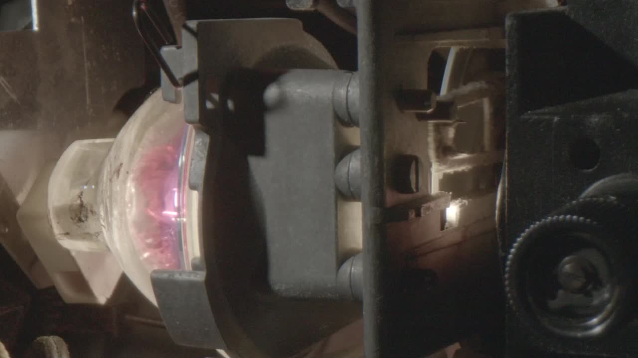 켜져 있는 8mm 프로젝터의 전구의 클로즈업, 16fps의 셔터