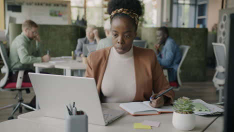 businesswoman taking notes in a modern office
