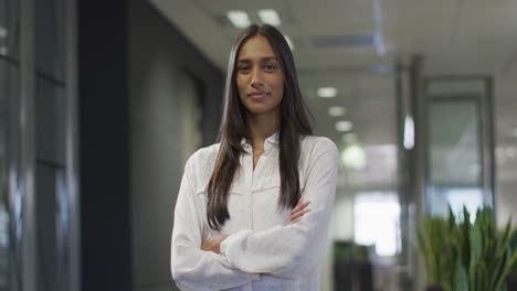 Video-of-happy-biracial-woman-looking-at-camera-in-office