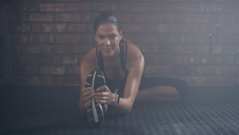 a young woman doing warmup exercises at the gym