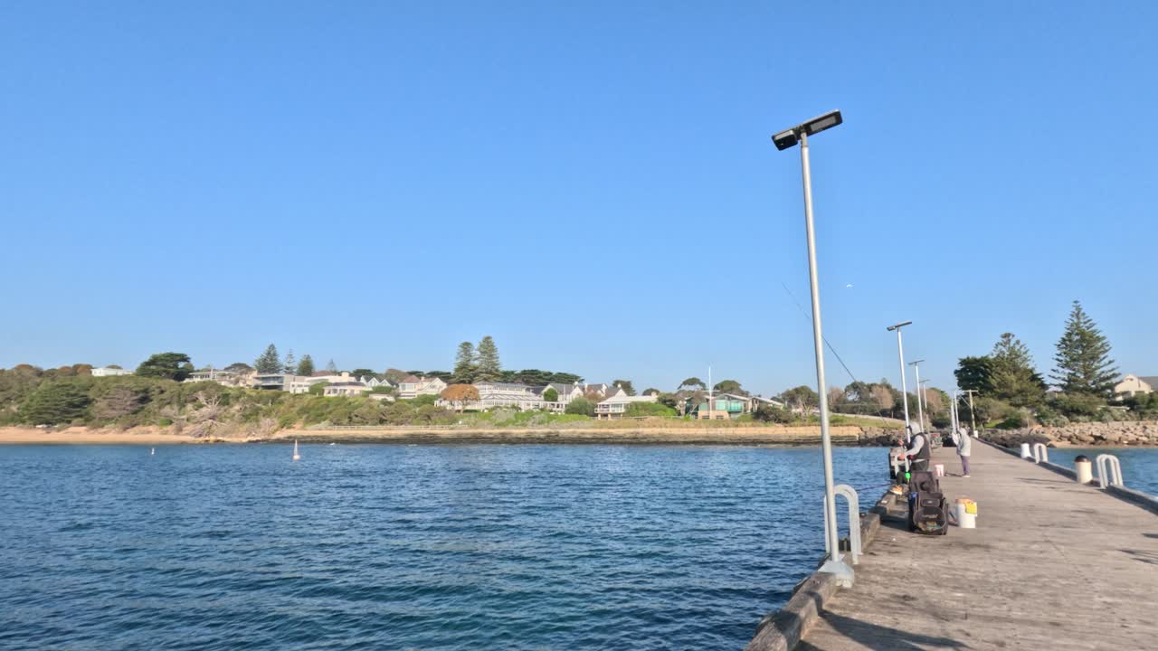 People fishing on a sunny Melbourne pier