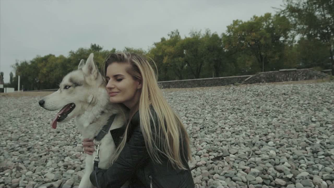 Woman and Husky Dog on a Rocky Beach