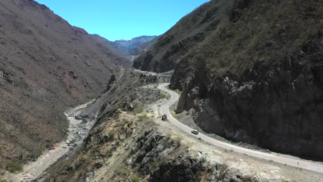 camión blanco conduciendo por una sinuosa carretera de montaña, amplia toma aérea de seguimiento