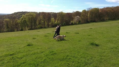 aerial shot of mature couple and dog on walk in countryside