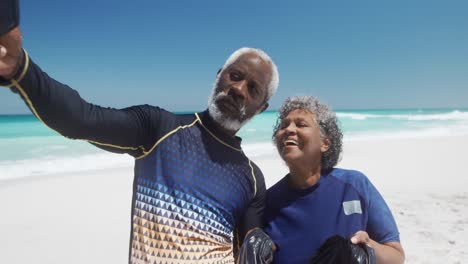 senior couple taking photos at the beach