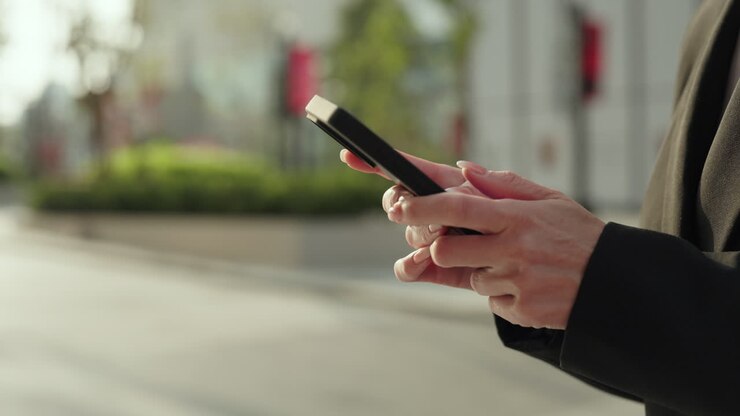 Donna d'affari che usa lo smartphone all'aperto