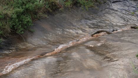 Eons-of-muddy-water-stream-eroded-narrow-channel-potholes-in-rock