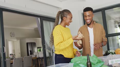 Happy-african-american-couple-recycling-waste