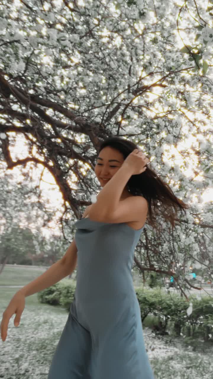 Woman in a Blue Dress amongst Blooming Spring Flowers