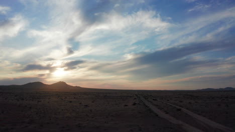 Hiperlapso-Del-Paisaje-Desértico-Durante-Una-Colorida-Puesta-De-Sol-Contra-Las-Montañas-Distantes---Gran-Angular-Delantero-De-La-Muñeca-Aérea