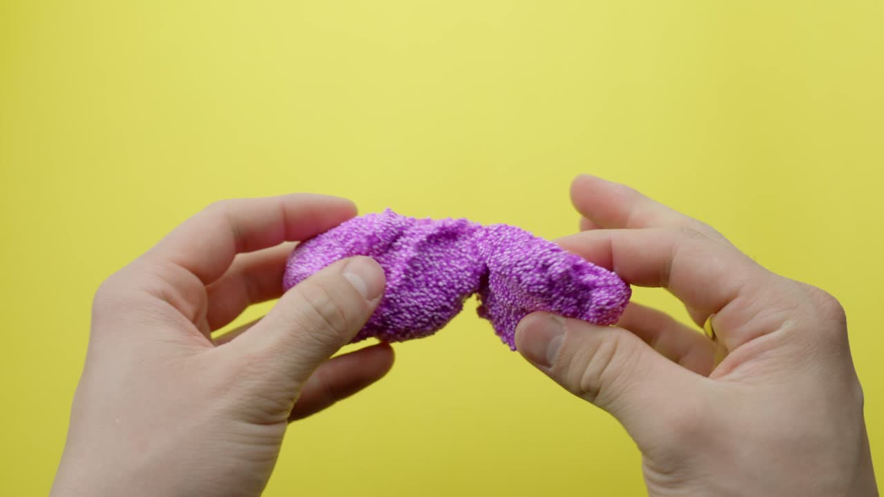 Purple floam with glitter in person hands, POV