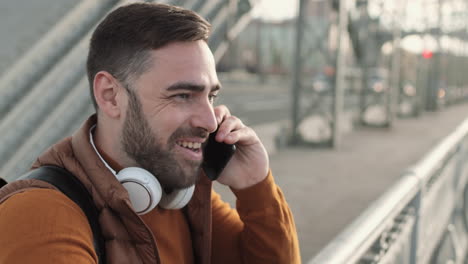 man talking on phone on bridge