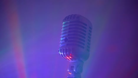 micrófono vintage con luces de discoteca en el escenario. actuación en vivo o concepto de karaoke.