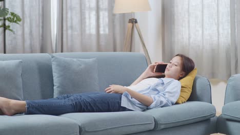 woman relaxing on a couch and talking on the phone