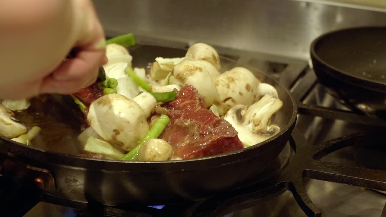 팬에 야채와 버섯을 곁들인 얇게 썬 소고기 요리