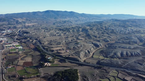 aerial view of a spanish valley with highway and farmland