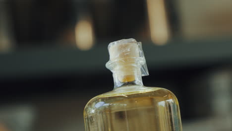 close up shot of plastic sealing a lid on a glass bottle of distilled gin, at high temperatures, industrial process in a gin distillery production