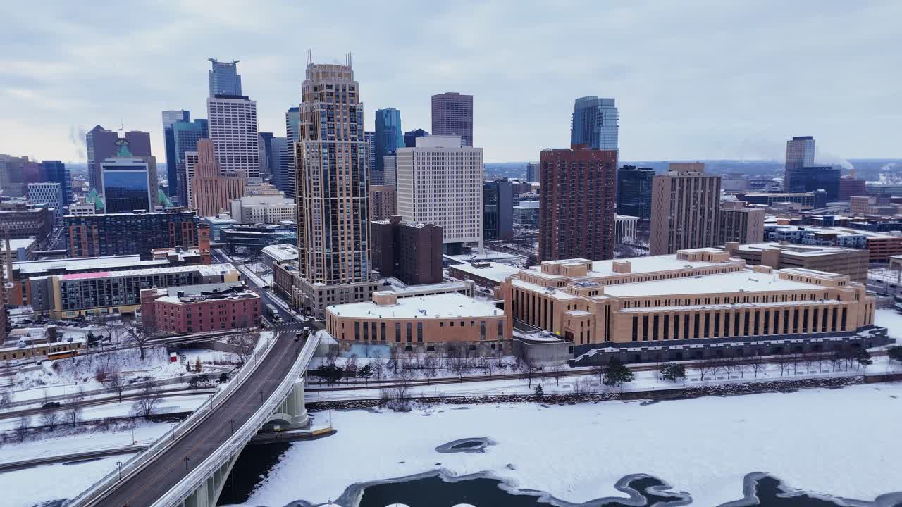 Minneapolis, Minnesota, ABD şehir merkezi silüeti, kışın donmuş Mississippi Nehri'ni geçen 3. Cadde köprüsüyle birlikte.