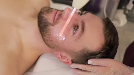man receiving facial treatment at a spa