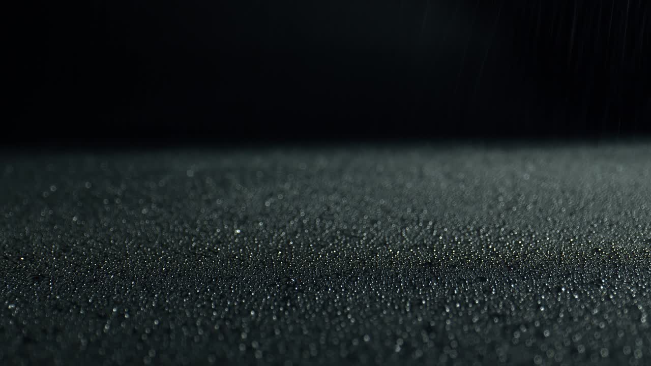 Glittering water droplets. Black surface in drops of water. Abstract wet surface.