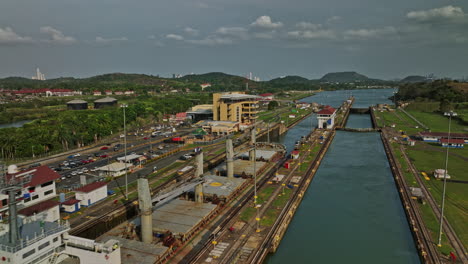 Panama-City-Aerial-V33-Low-Flyover-Miraflores-Schleusenmechanismus,-Der-Details-Des-Frachttankschiffs-Erfasst,-Das-An-Der-Station-über-Die-Schmale-Kanalwasserstraße-Fährt-–-Aufgenommen-Mit-Mavic-3-Cine-–-März-2022