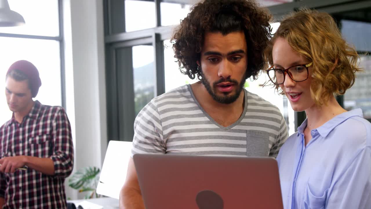 Business executives discussing over laptop in meeting