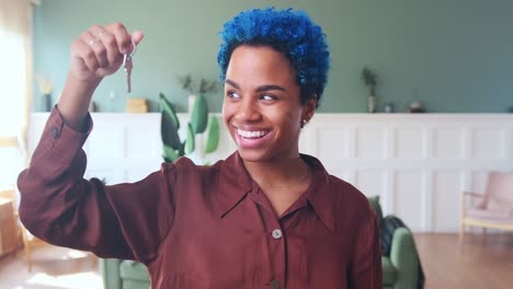 young beautiful happy african american woman homeowner shows key to new