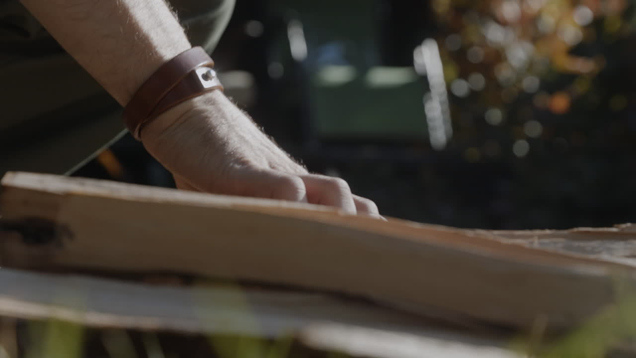 A man picks up wooden logs