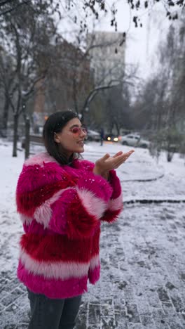 woman enjoying the snow in a pink and red fur coat