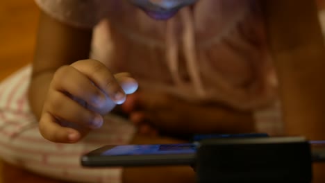 child girl using digital tablet sitting on a table