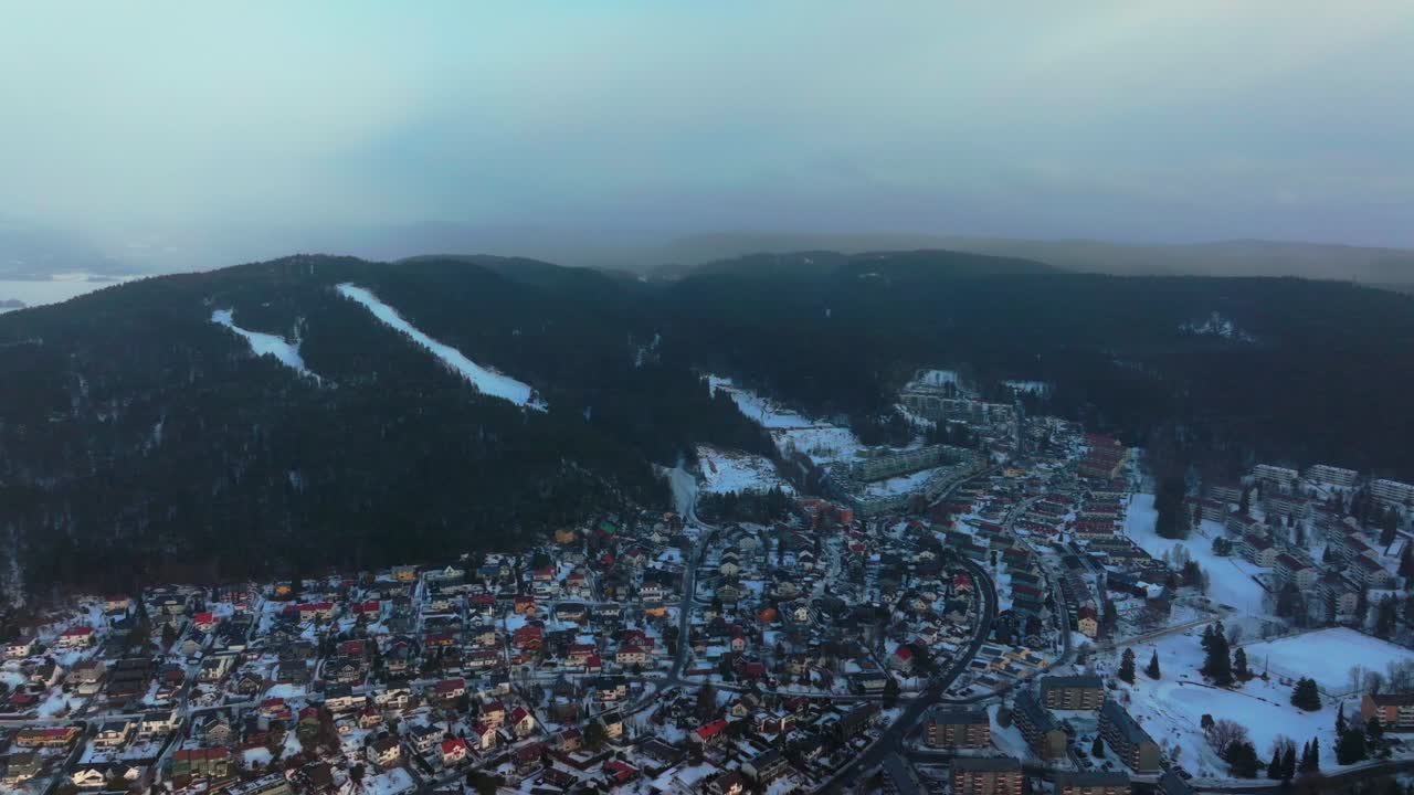 Snowing Bjerke Arvoll Tonsengagen Oslo Norge Norway Skikurs skisenter aerial drone cold cloudy winter day gray skies city neighborhood buildings landscape Arctic circle right motion