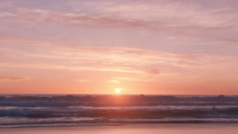 Wunderschöner-Strand-Bei-Sonnenuntergang-Mit-Wellen,-Die-Sich-An-Der-Friedlichen-Inselküste-Brechen