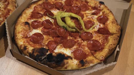 rotating shot of delicious italian pizzas delivered in boxes on the table, pizza with burned crust