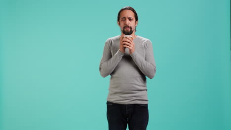 el hombre se siente cansado, bebe café para despertar.